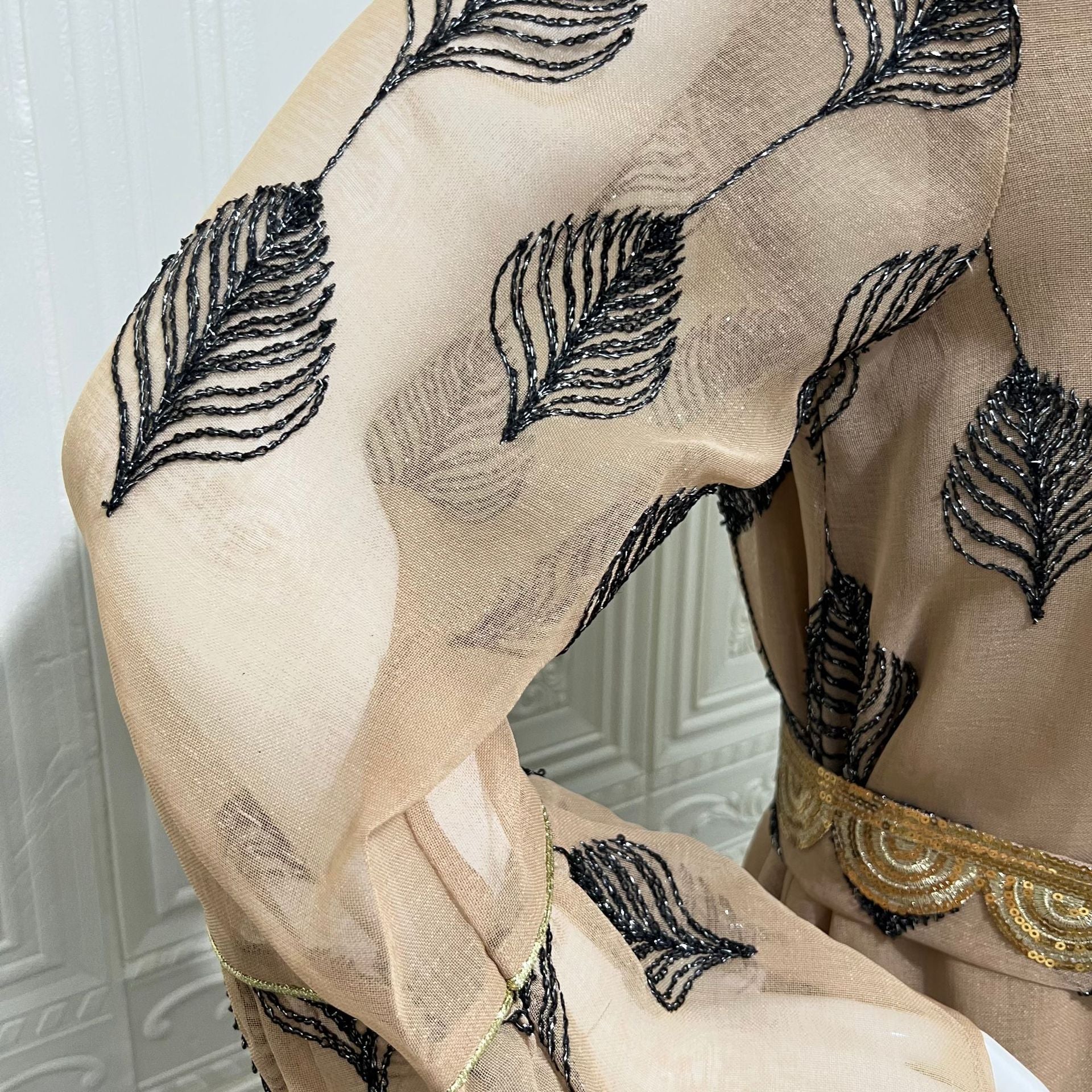 Desert FYP Viral Khaleeji Two-Piece Modest Co-ord Warm Sand Tone Light Woven Outer Kaftan Matching Solid Slip Dress All Over Vintage Black Leaf Print Handcrafted Golden Lace Trim Placket Elastic Gold Waist Belt Bell Flared Tiered Long Sleeve Ruffled
